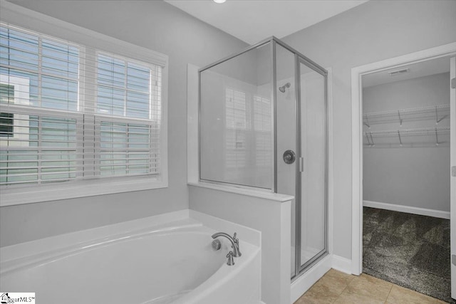 bathroom with separate shower and tub and tile patterned floors