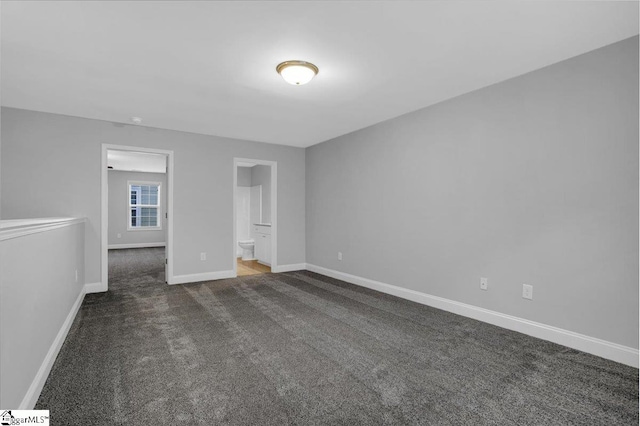 interior space with dark carpet and ensuite bath