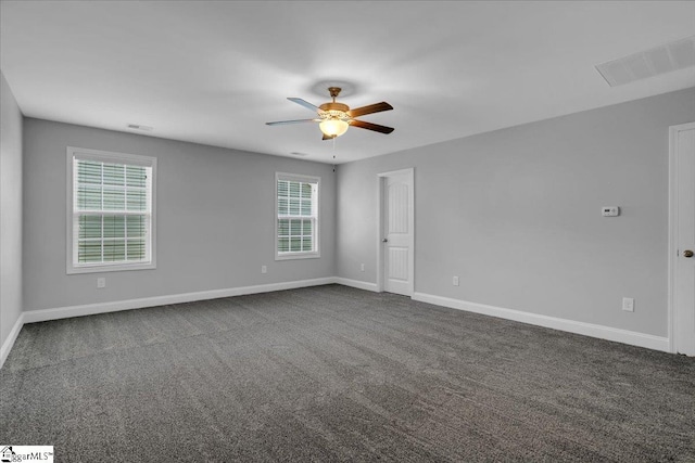 spare room with dark carpet and ceiling fan