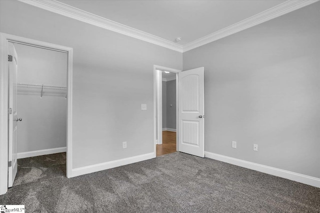 unfurnished bedroom featuring ornamental molding, dark colored carpet, and a closet