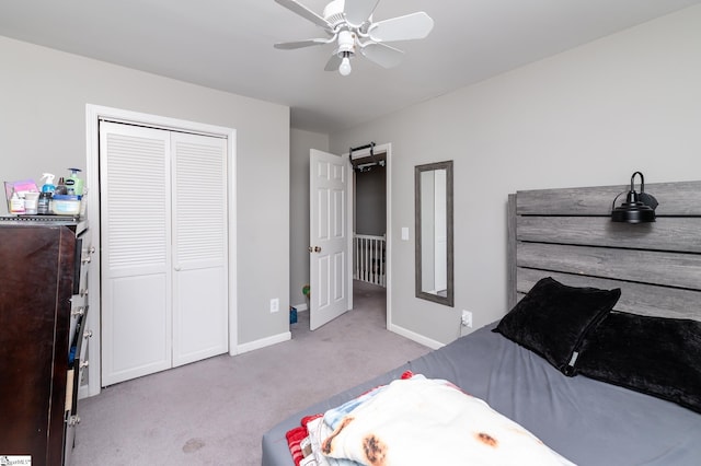 bedroom with a closet, light colored carpet, and ceiling fan