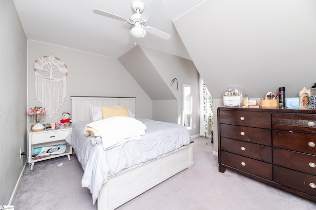 carpeted bedroom with ceiling fan and vaulted ceiling