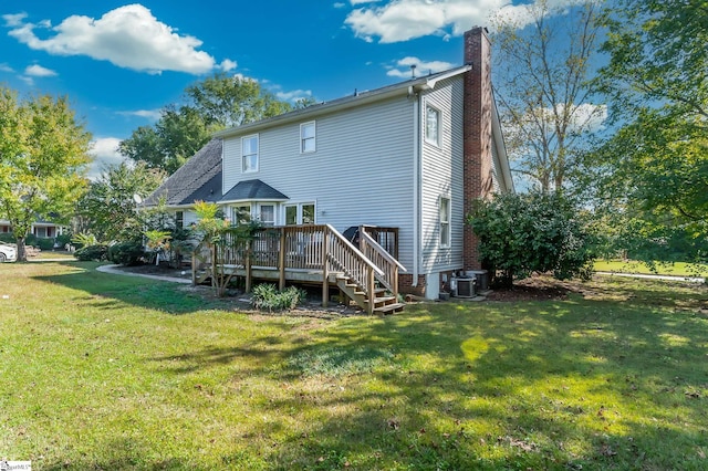 back of property featuring central air condition unit, a deck, and a lawn