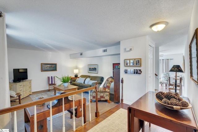 living room with a textured ceiling and light hardwood / wood-style flooring