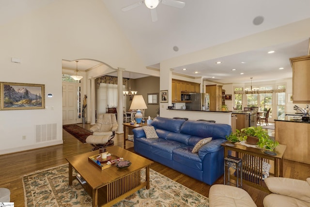 living room with ornamental molding, decorative columns, sink, ceiling fan with notable chandelier, and dark hardwood / wood-style flooring