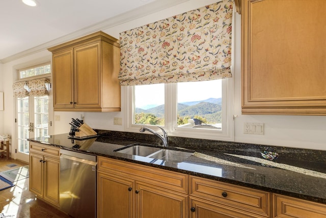 kitchen with dishwasher, dark stone countertops, crown molding, a mountain view, and sink