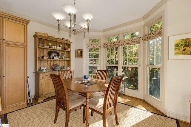 dining room featuring ornamental molding, a chandelier, and light wood-type flooring