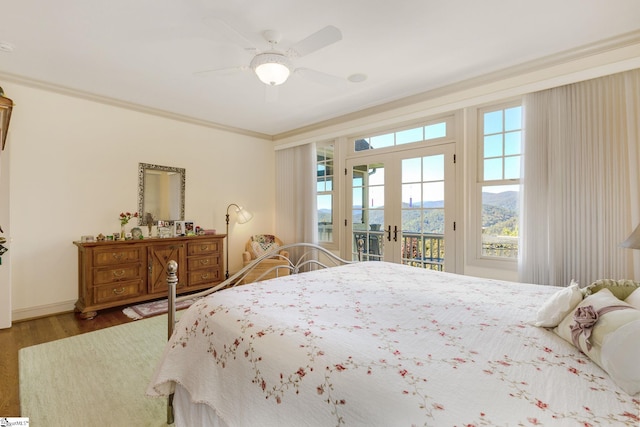 bedroom featuring access to exterior, a mountain view, wood-type flooring, crown molding, and ceiling fan