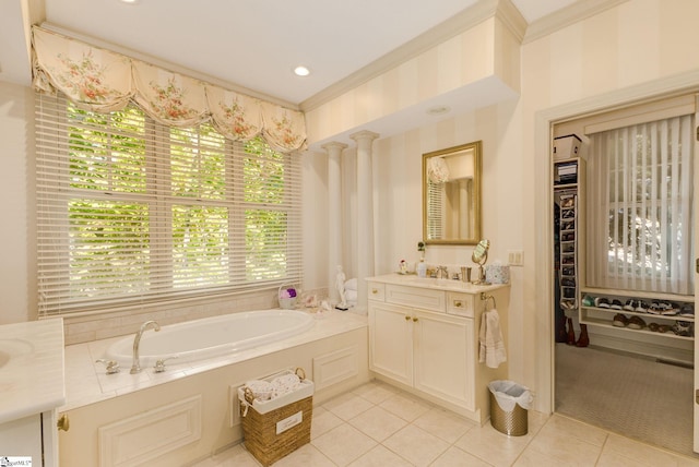 bathroom with tile patterned flooring, a bathtub, ornamental molding, decorative columns, and vanity