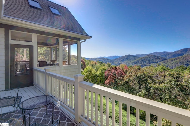 wooden terrace featuring a sunroom and a mountain view