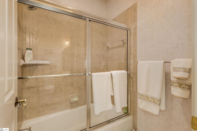 bathroom with bath / shower combo with glass door