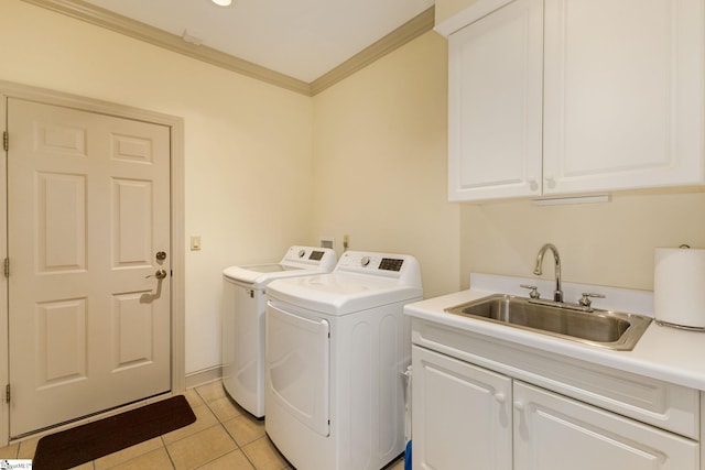 clothes washing area featuring cabinets, light tile patterned floors, ornamental molding, washing machine and dryer, and sink