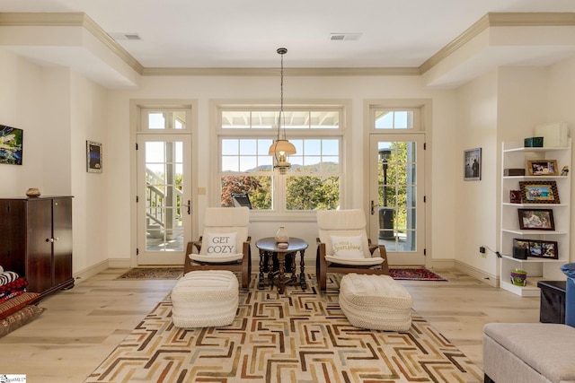 sitting room featuring ornamental molding and light hardwood / wood-style floors