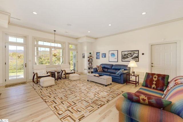 living room with light hardwood / wood-style floors and ornamental molding