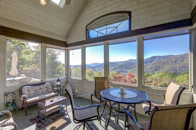 sunroom / solarium featuring a mountain view, lofted ceiling, and a wealth of natural light