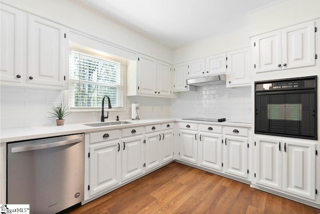 kitchen featuring decorative backsplash, white cabinetry, black appliances, light hardwood / wood-style floors, and sink