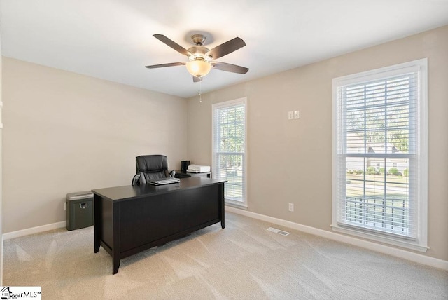 office space featuring light carpet, plenty of natural light, and ceiling fan