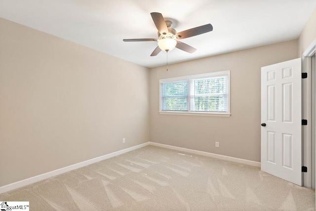 carpeted spare room with ceiling fan