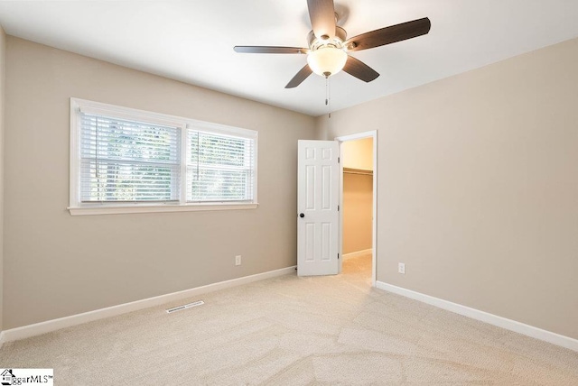 carpeted empty room featuring ceiling fan