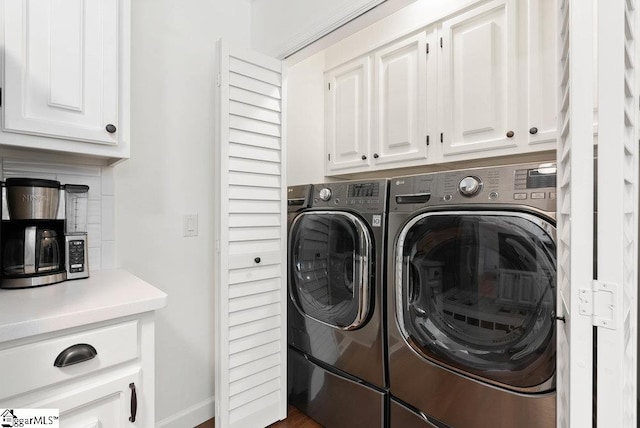 washroom featuring washing machine and dryer and cabinets