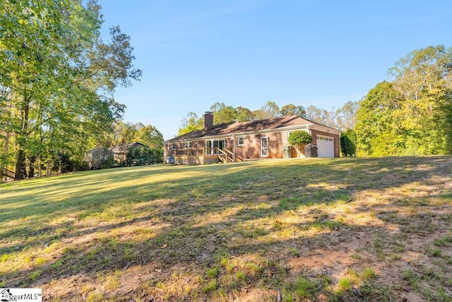 view of front of home featuring a wooden deck, a front lawn, and a garage