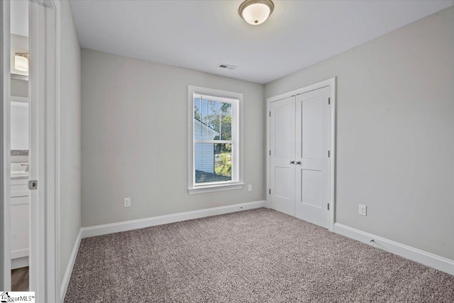 unfurnished bedroom with carpet flooring and a closet