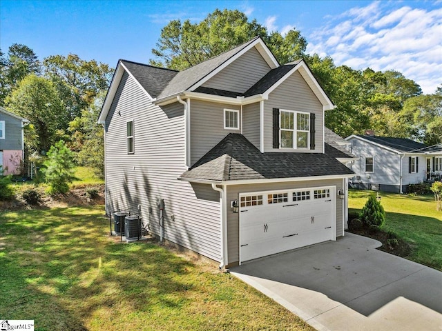 view of front of home featuring a front yard, central AC, and a garage