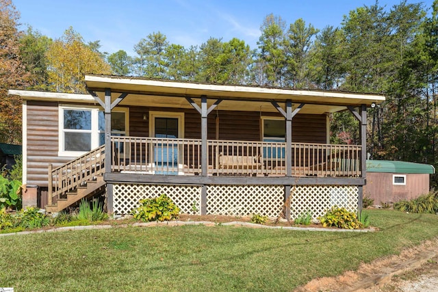 rear view of property with a storage unit and a lawn