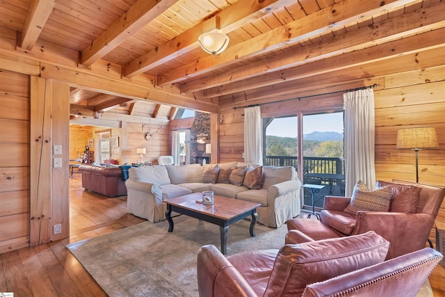 living room featuring wood ceiling, hardwood / wood-style flooring, wood walls, beamed ceiling, and a mountain view