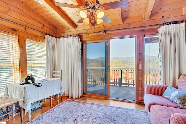 interior space featuring a mountain view, lofted ceiling with beams, wooden ceiling, and ceiling fan