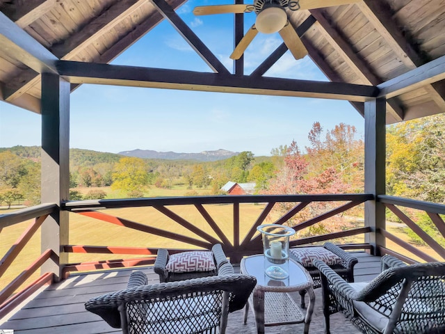 wooden terrace featuring a mountain view and ceiling fan