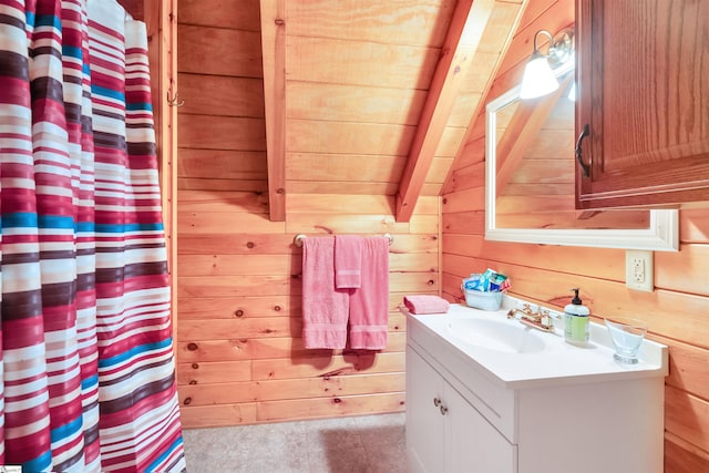 bathroom featuring lofted ceiling, wooden walls, wooden ceiling, vanity, and walk in shower