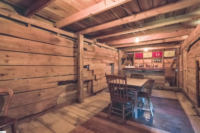 dining area with beam ceiling, wood walls, dark hardwood / wood-style floors, and wooden ceiling