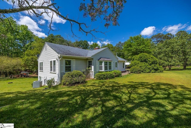 view of front of house featuring a front yard and central AC