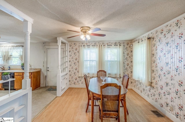 dining space featuring plenty of natural light, a textured ceiling, and light wood-type flooring