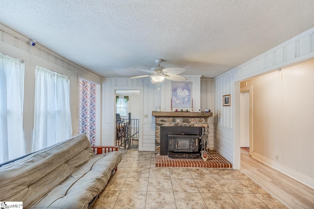 living room featuring light hardwood / wood-style floors, a textured ceiling, and ceiling fan