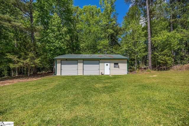 view of outdoor structure featuring a garage and a lawn