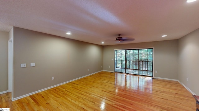 spare room with light hardwood / wood-style floors, a textured ceiling, and ceiling fan