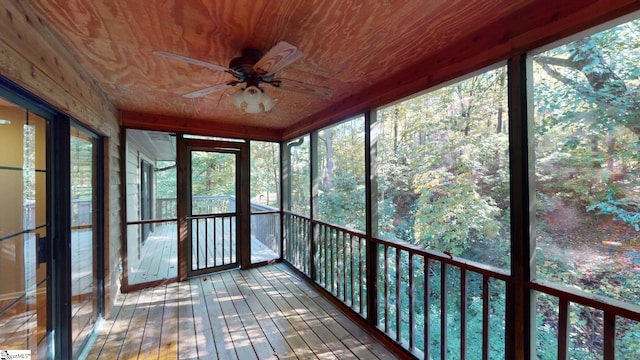 unfurnished sunroom featuring wooden ceiling and ceiling fan