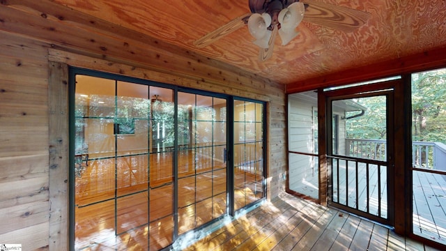 unfurnished sunroom with ceiling fan and wooden ceiling