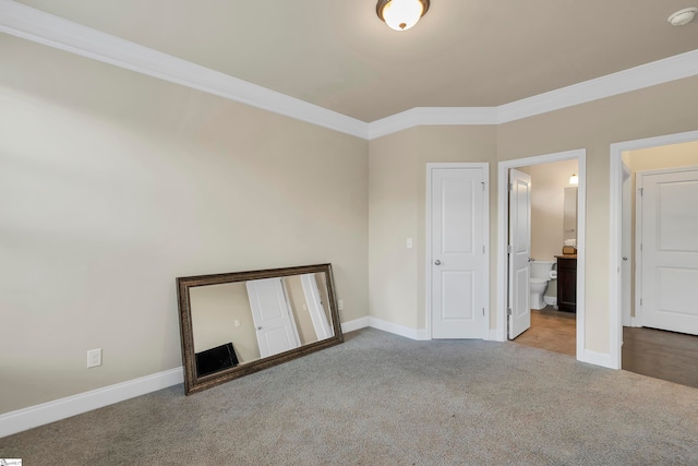 unfurnished bedroom with ensuite bath, crown molding, and carpet floors