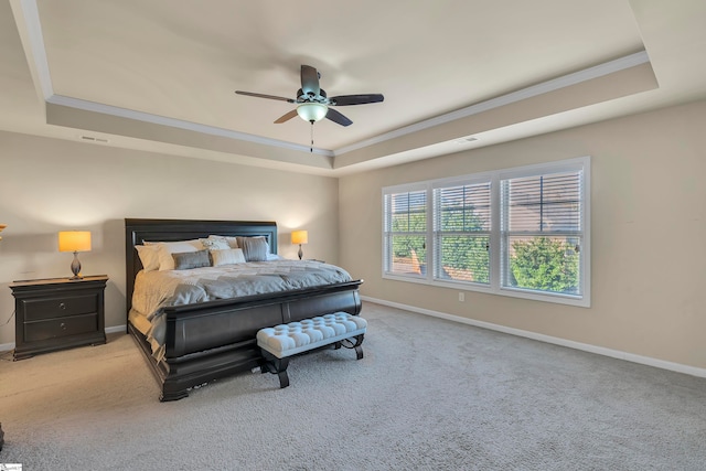 bedroom with light carpet, crown molding, ceiling fan, and a raised ceiling