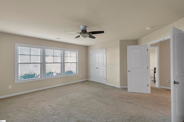 unfurnished bedroom with light carpet, a closet, and ceiling fan