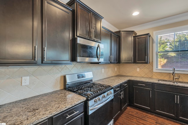 kitchen with tasteful backsplash, appliances with stainless steel finishes, sink, ornamental molding, and dark hardwood / wood-style floors