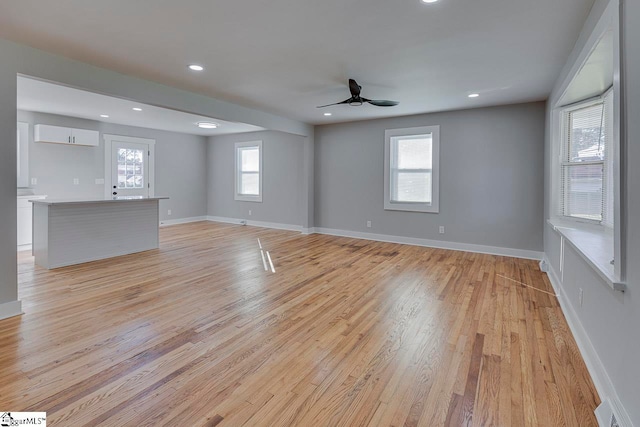 empty room featuring light hardwood / wood-style flooring, a healthy amount of sunlight, and ceiling fan