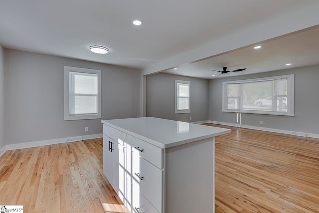 kitchen featuring white cabinetry, a center island, a wealth of natural light, and light wood-type flooring