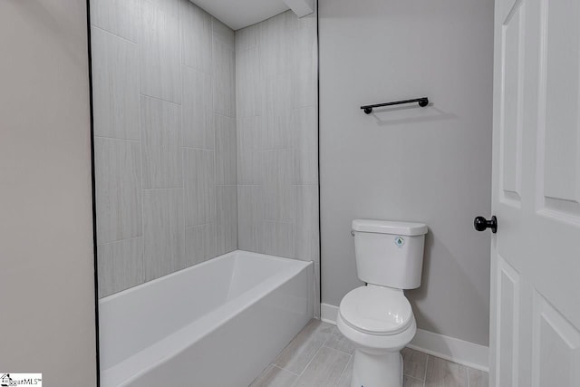 bathroom with tiled shower / bath combo and toilet