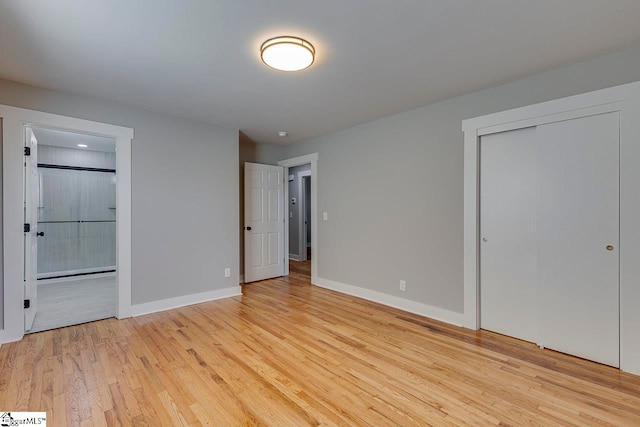 unfurnished bedroom featuring ensuite bathroom and light wood-type flooring