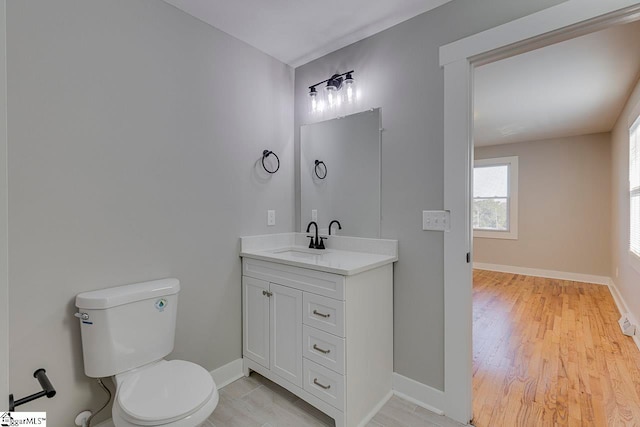 bathroom with vanity, toilet, and wood-type flooring