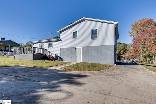 rear view of house featuring a yard and a deck